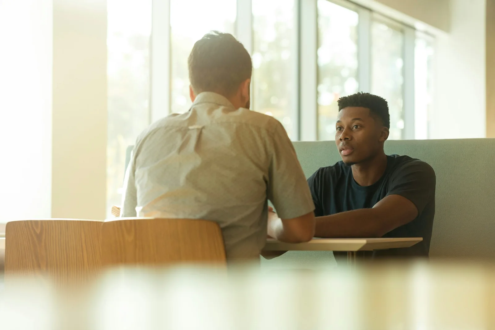 Un premier échange entre deux personnes assises à une table.