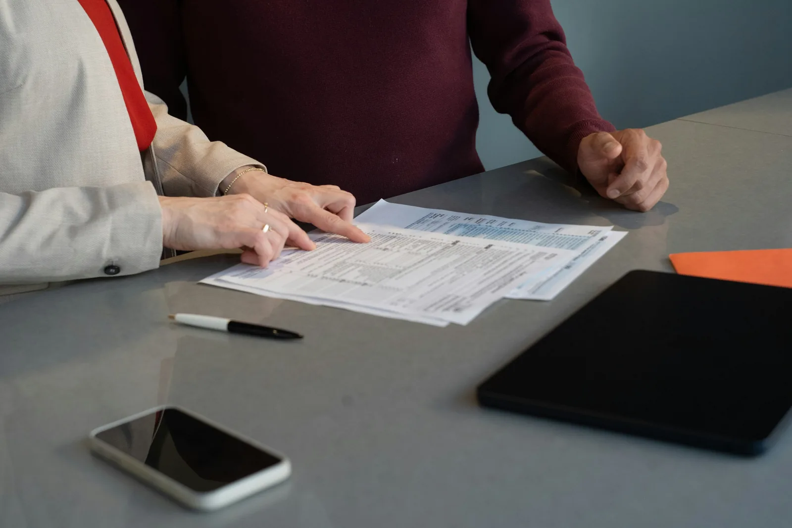 Deux personnes examinent des tableaux imprimés.