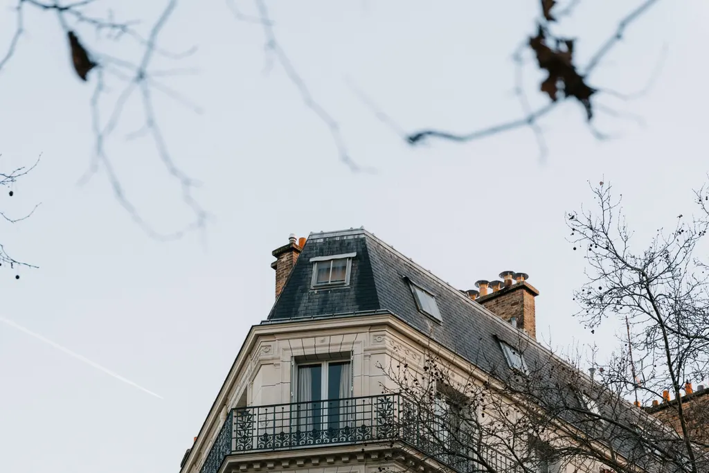 Façade d’un immeuble parisien à balcons, dans la lumière d’hiver