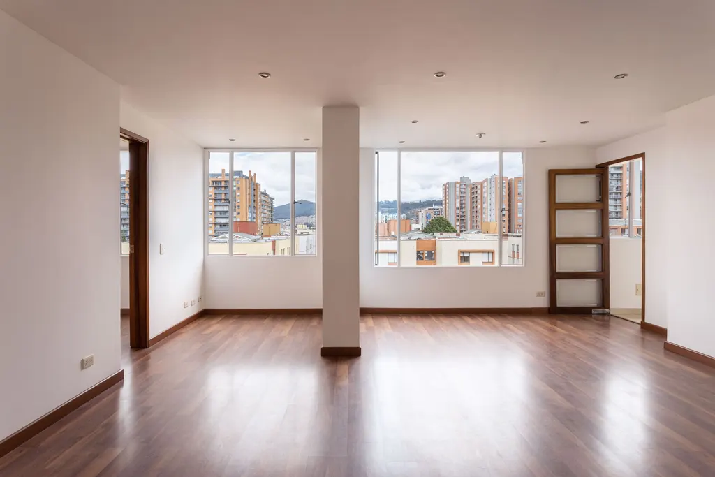 Pièce d’appartement vide, avec de grandes fenêtres et un parquet