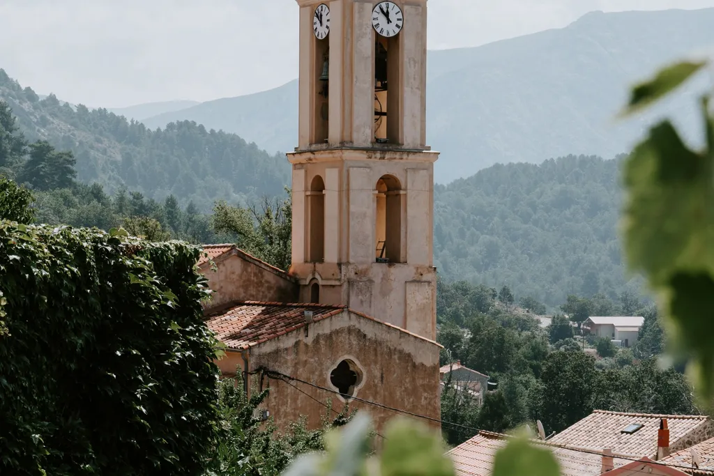 Clocher d’une église de village au-dessus des toits voisins